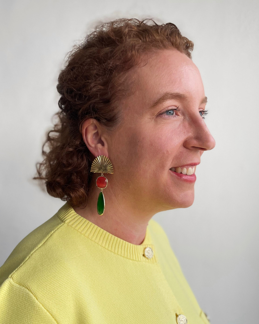 Lina lleva los pendientes Bailar de Luz. Bailar de Luz dorada con colgante de piedra naranja y verde.