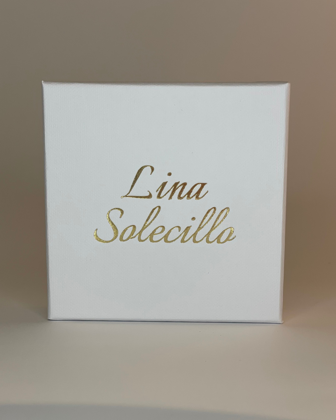 Imagen de la caja de regalo de Lina Solecillo. La caja es blanca con letras doradas.