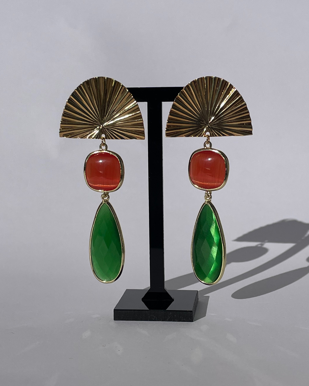 Bailar de Luz - el pendiente tiene un cierre de oro y dos piedras en verde y naranja como colgante.