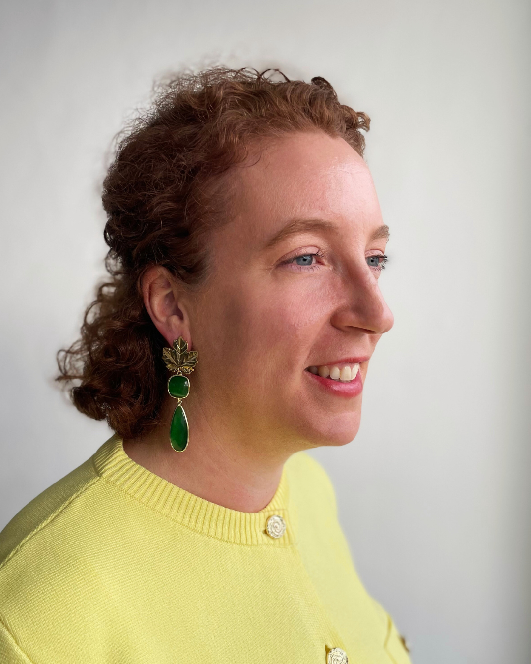 Lina lleva los pendientes Brillo Otonal. Brillo Otonal dorada con colgante de piedra verde.