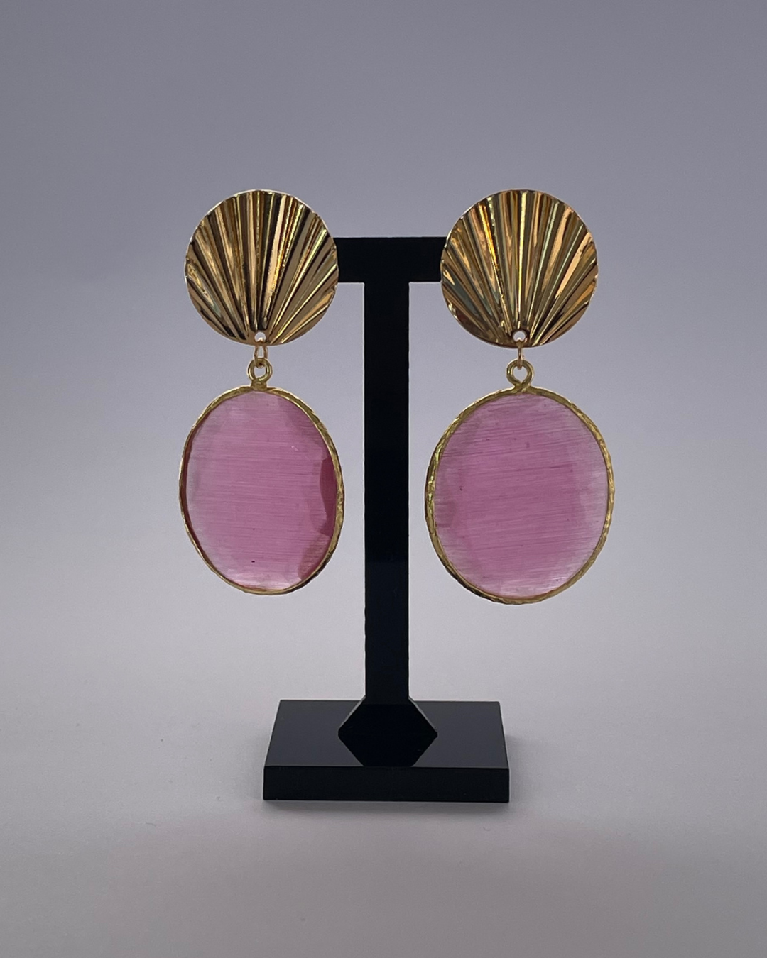 Concha - el pendiente tiene un cierre de oro y una piedra rosa como colgante.