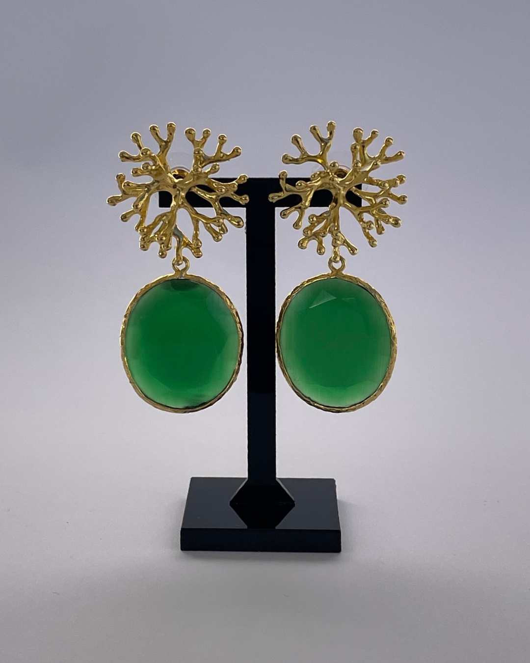 Coralina - el pendiente tiene un cierre de oro y una piedra verde como colgante.