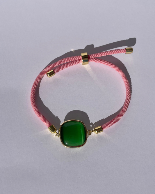 Primer plano de la pulsera rosa con piedra verde.