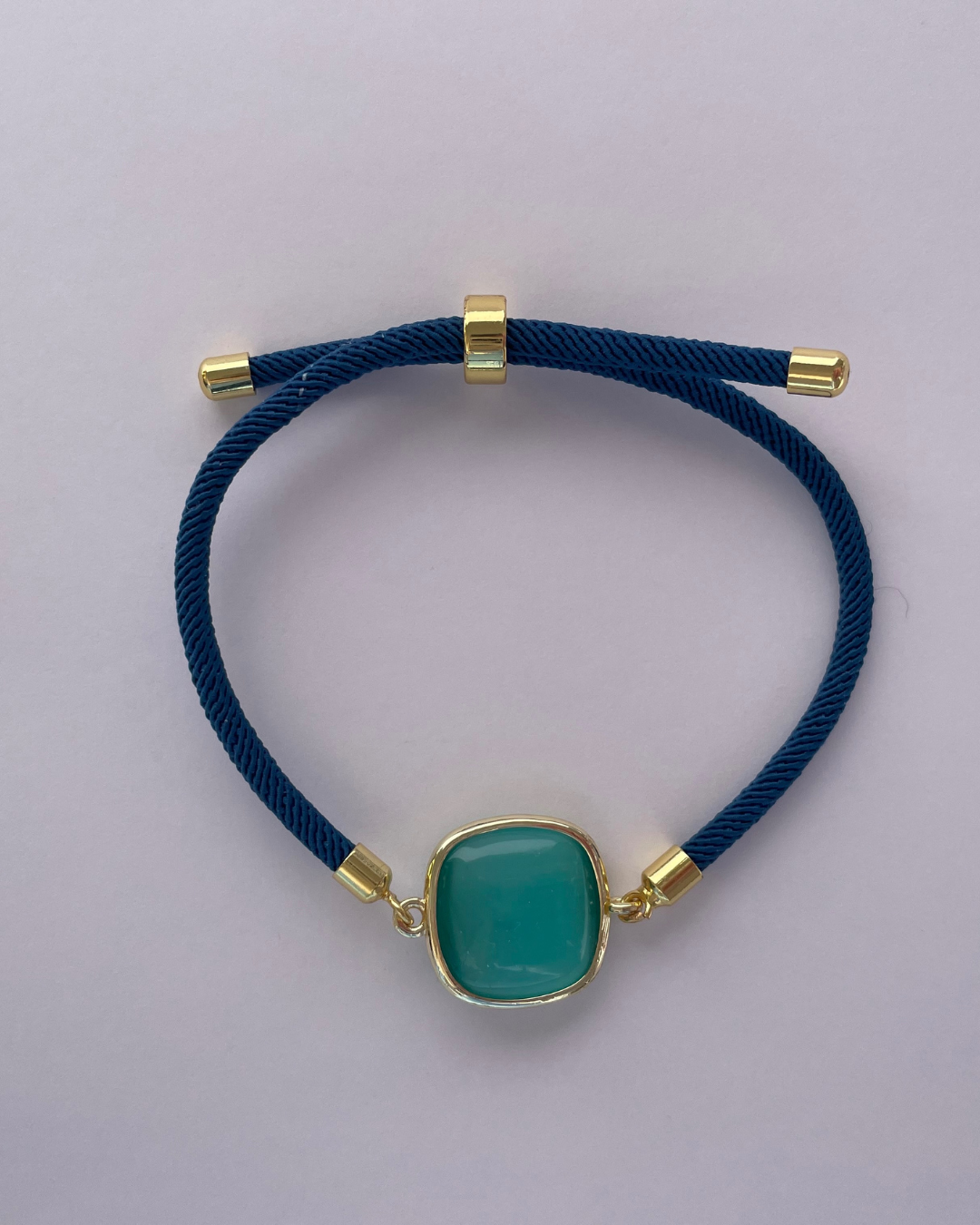 Primer plano de la pulsera azul con piedra verde aqua.