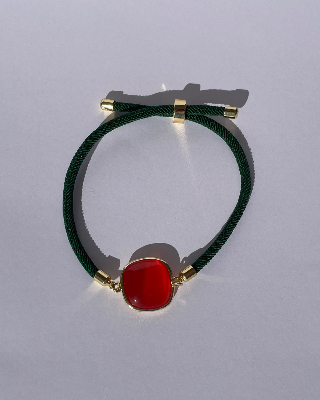 Primer plano de la pulsera verde con piedra naranja.